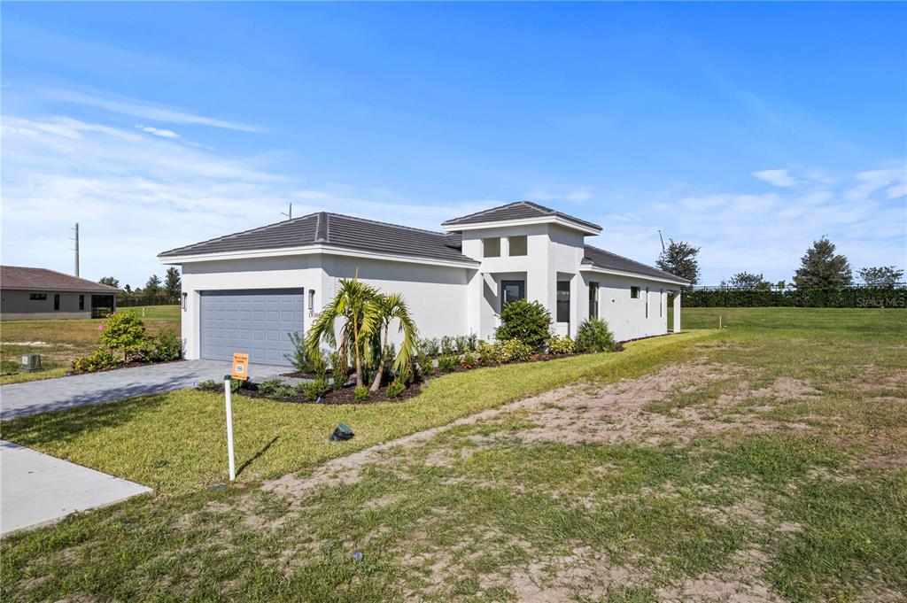 A modern, single-story white house with a gray tile roof and a two-car garage — 18388 ROCKPORT PLACE, LAKEWOOD RANCH, FL