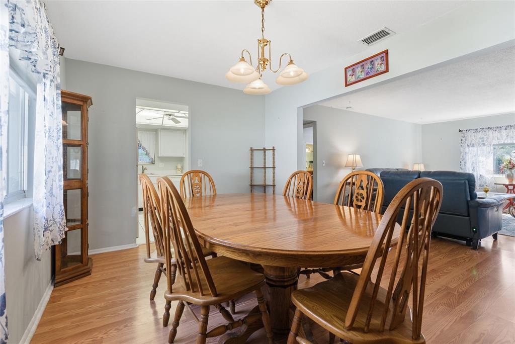 An empty room features light gray walls, wood-look flooring, and a window with floral curtains — 1141 MERLE WAY UNIT 14, SARASOTA, FL