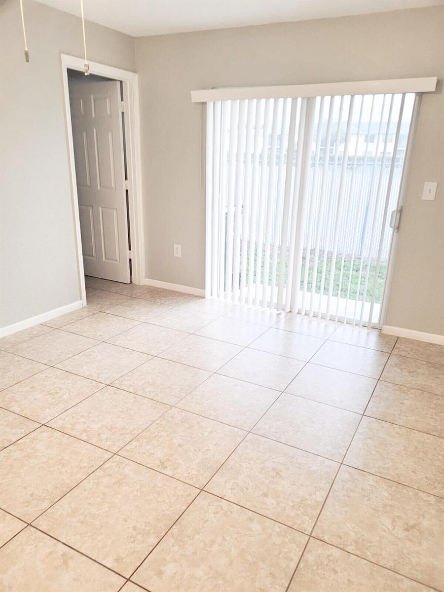 A room with light-colored tile flooring, a doorway, and a sliding glass door with blinds — 524 Southridge Road, Delray Beach FL 33444, DELRAY BEACH, FL