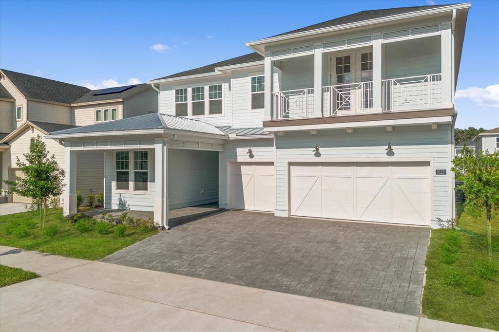 A two-story light blue house features a paved driveway, a covered porch, and a balcony — 3113 EXPEDITION DRIVE, ST CLOUD, FL