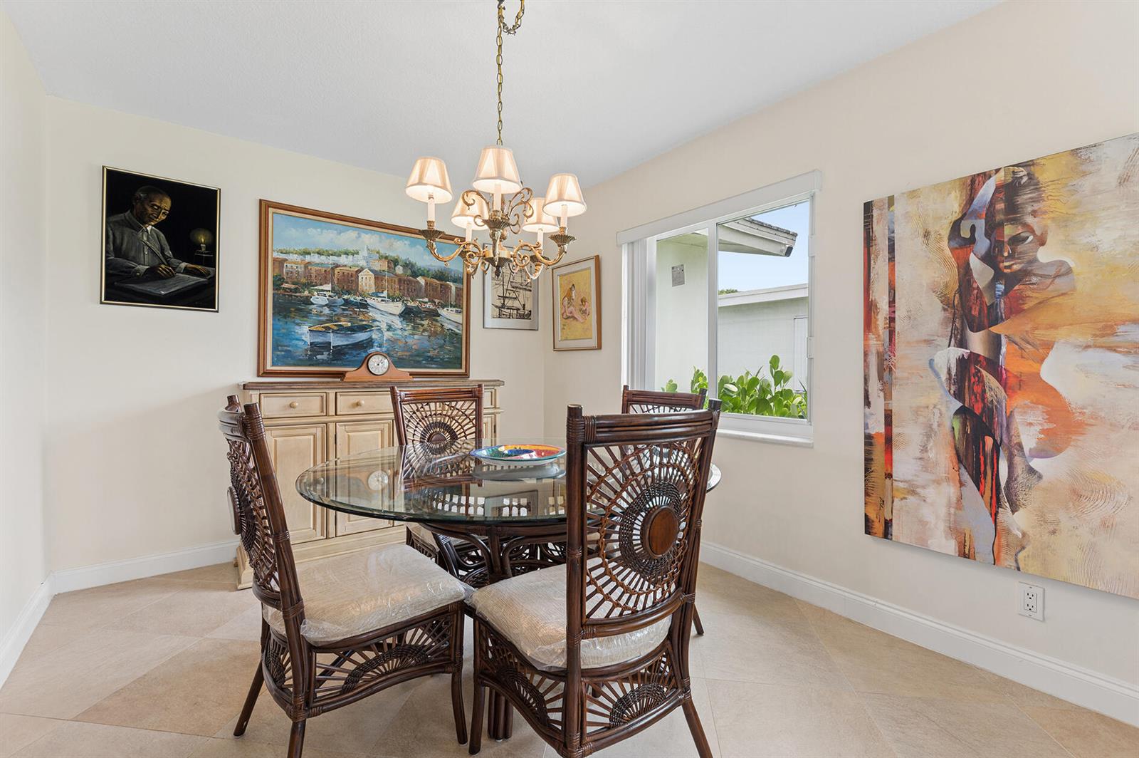 A dining room features a glass-topped rattan table, a chandelier, and several pieces of wall art — 709 SW 15th Street, Boynton Beach FL 33426, BOYNTON BEACH, FL