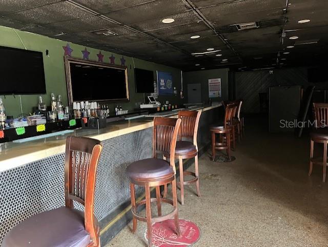 A commercial bar interior features a long counter, wooden stools, and a dark drop ceiling — 3607 N NEBRASKA AVENUE, TAMPA, FL