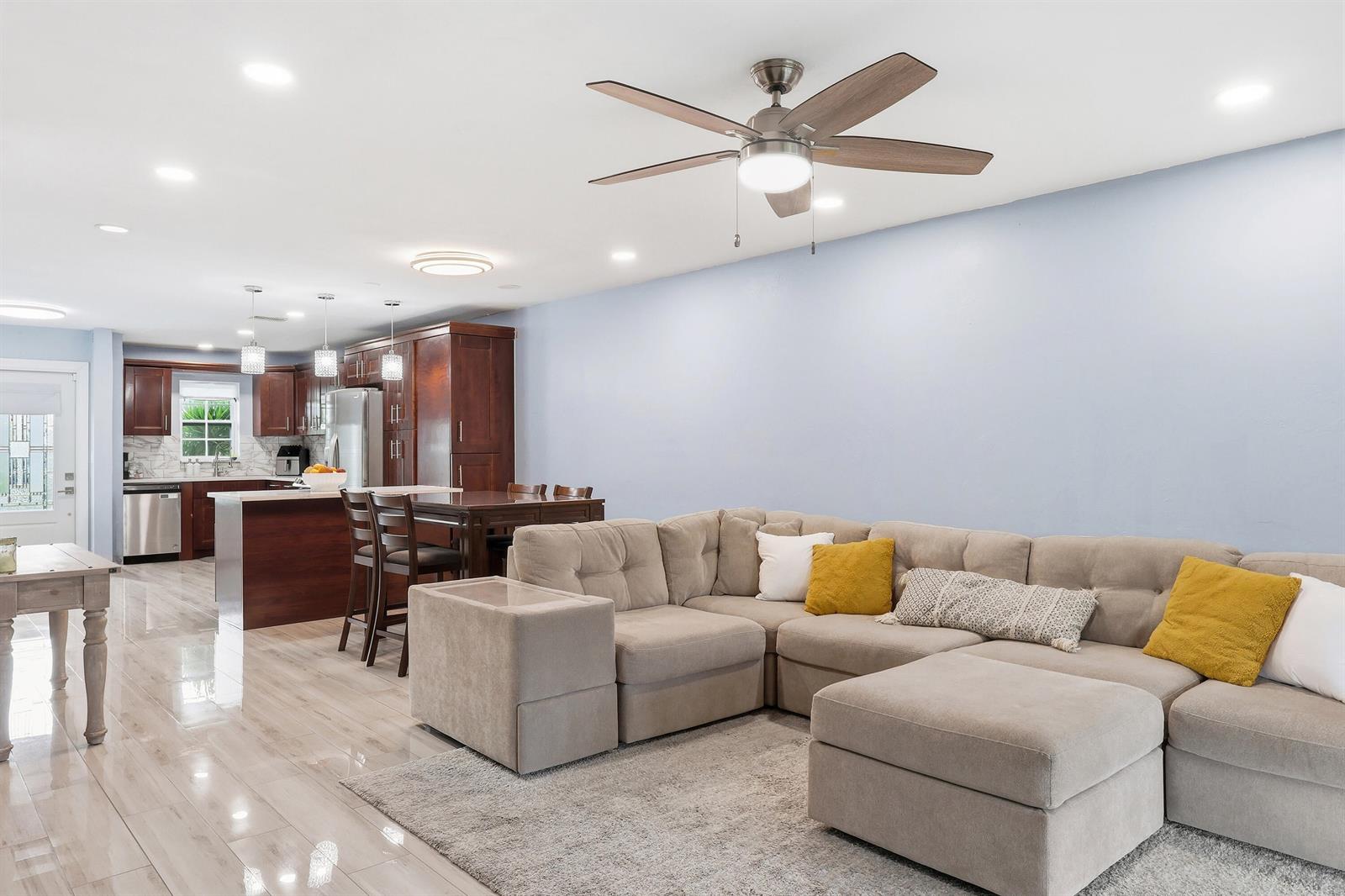 A living room with a sectional sofa and a kitchen with wood cabinets and island — 2520 SW 14th Court # 44, Boynton Beach FL 33426, BOYNTON BEACH, FL