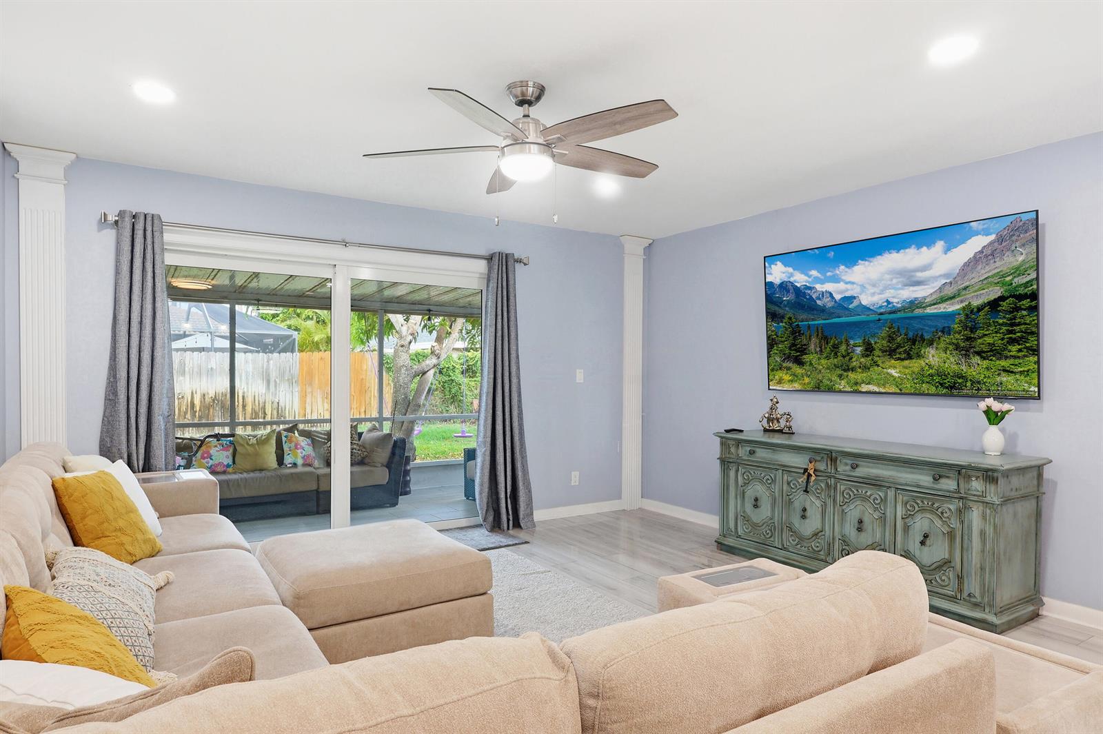A living room features a sectional sofa, a television, and a sliding door to a patio — 2520 SW 14th Court # 44, Boynton Beach FL 33426, BOYNTON BEACH, FL