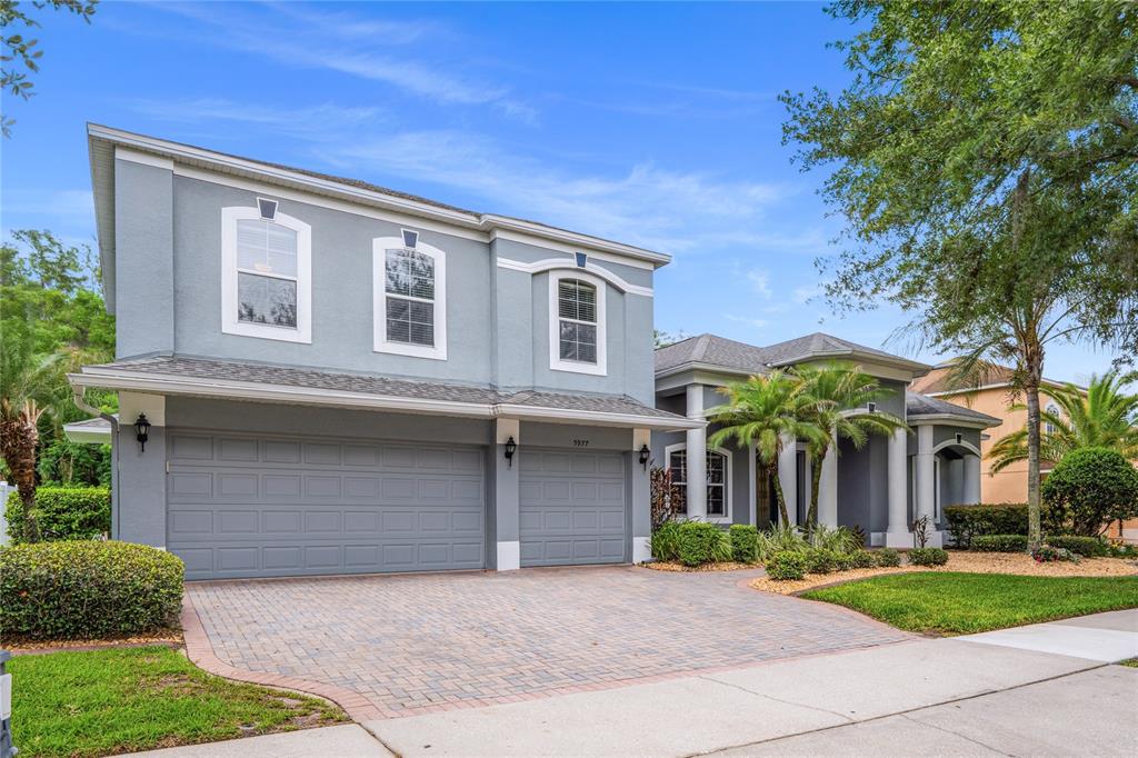 A two-story gray house with a three-car garage and a paved driveway — 5977 LAKE MELROSE DRIVE, ORLANDO, FL