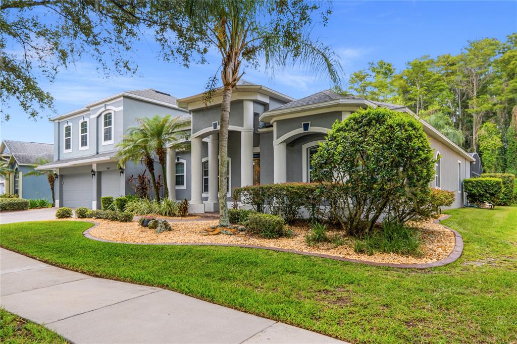 A gray two-story house with a columned entryway and a landscaped front yard — 5977 LAKE MELROSE DRIVE, ORLANDO, FL