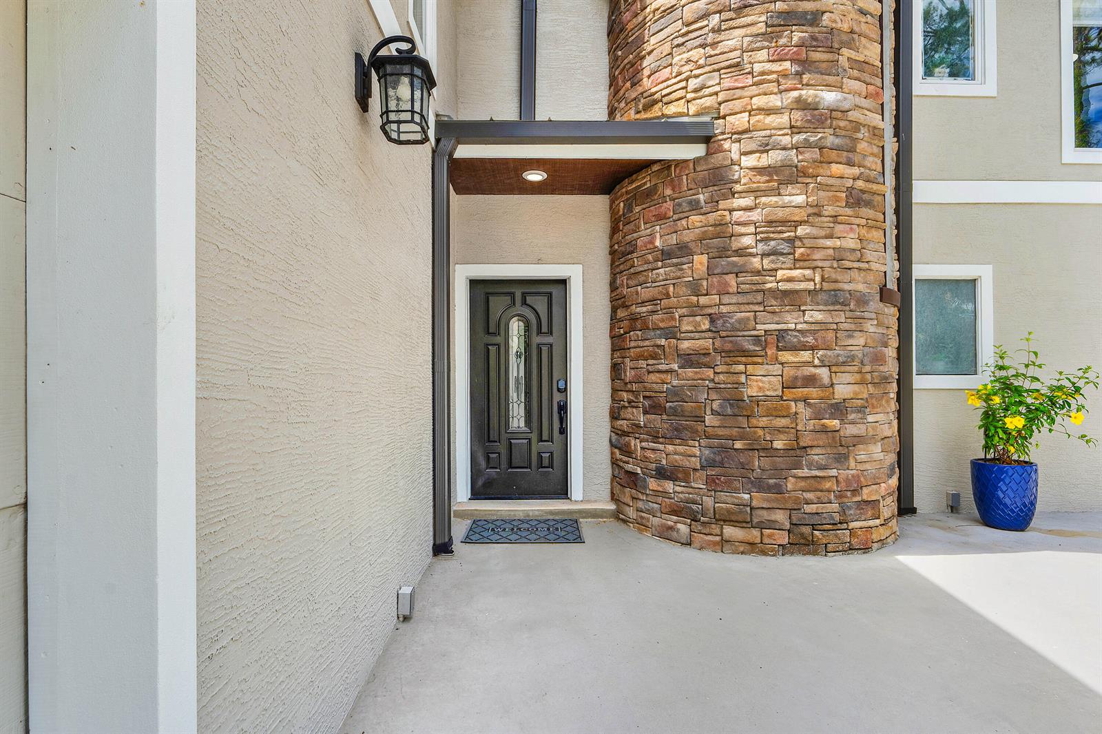 A front entryway features a dark door, a stone-clad turret, and a concrete porch — 9743 169th Court N, Jupiter FL 33478, JUPITER, FL