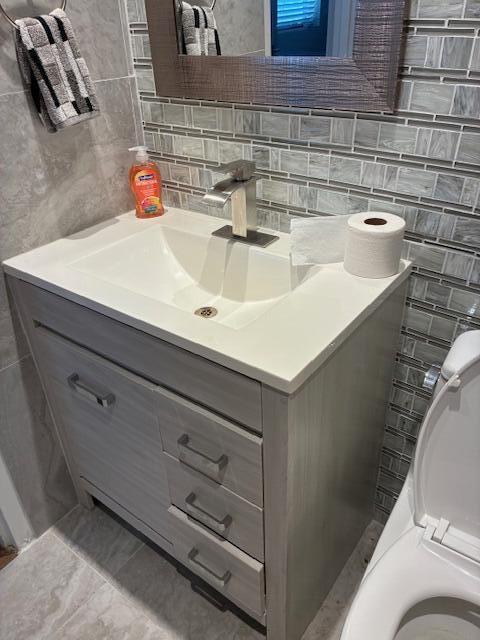 A bathroom vanity with a white sink, chrome faucet, and gray wood-look drawers — 195 Monaco E, Delray Beach FL 33446, DELRAY BEACH, FL