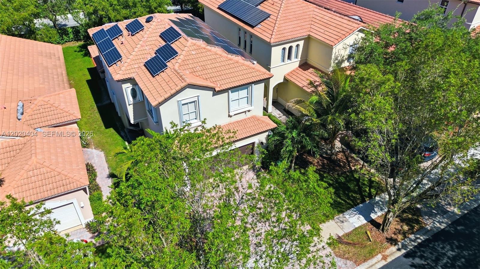 An aerial view shows two suburban houses with tile roofs and rooftop solar panels — 977 NE 37th Pl, Homestead FL 33033, HOMESTEAD, FL