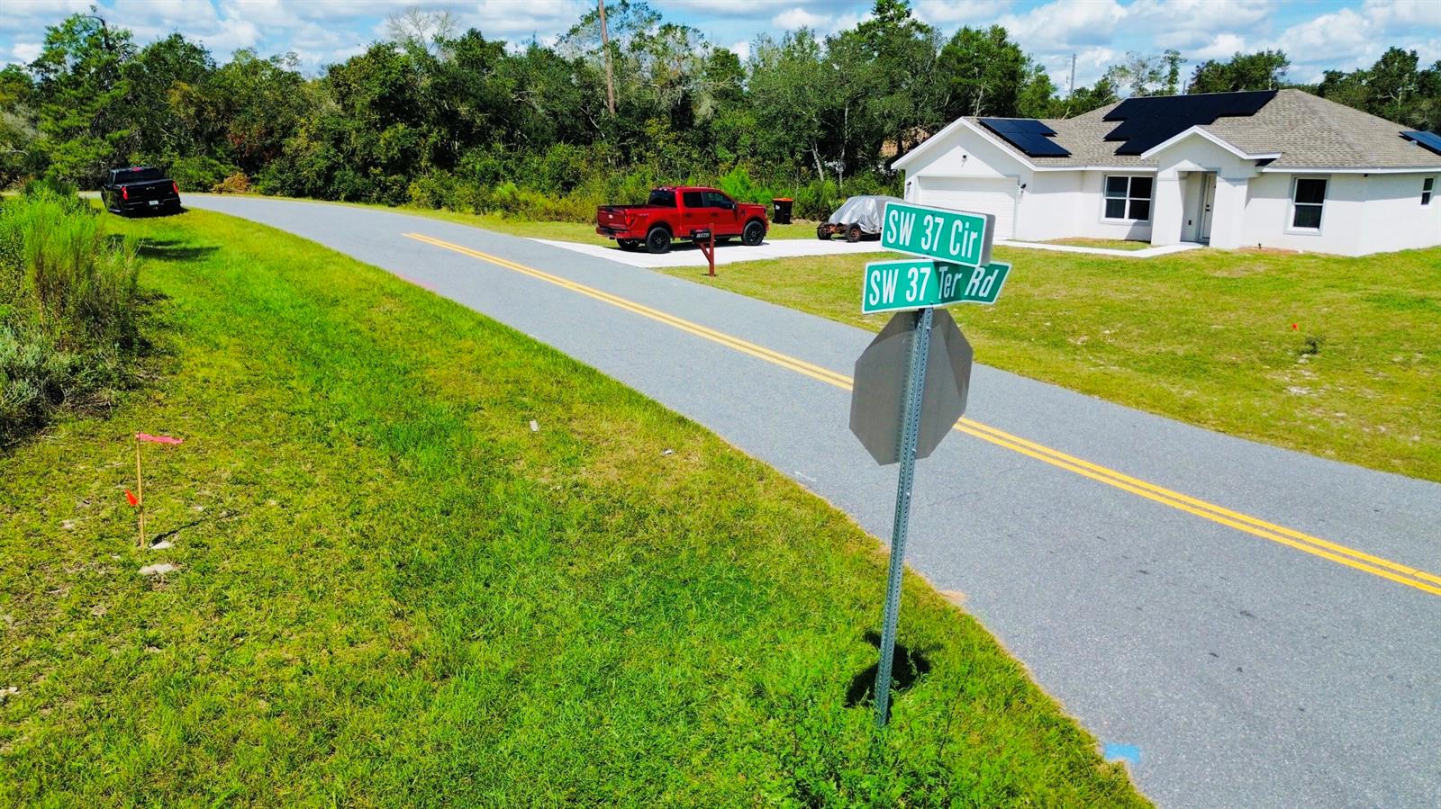An aerial view shows a house with solar panels, a red truck, and street signs — Tbd SW 37th Circle, Ocala FL 34473, OCALA, FL