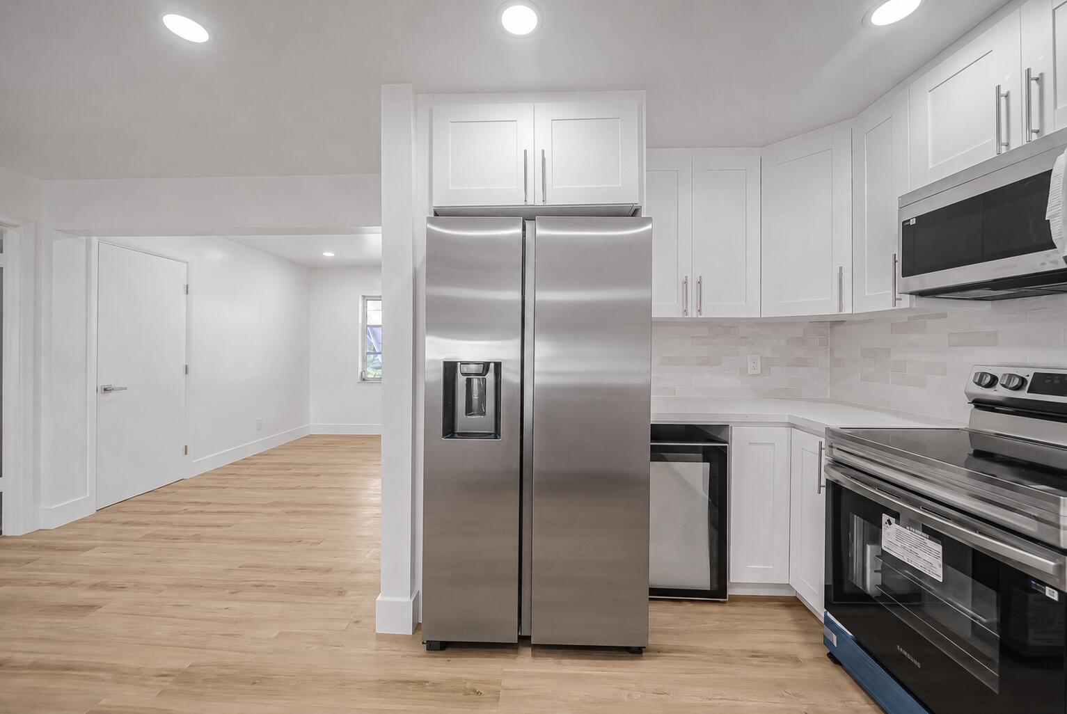 A kitchen with white cabinets, stainless steel appliances, and light wood flooring — 2106 Alfred Drive, Boynton Beach FL 33426, BOYNTON BEACH, FL