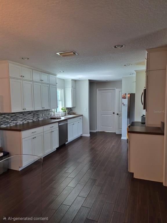 A kitchen features white cabinets, dark wood countertops, a tiled backsplash, and dark wood flooring — 2729 HARRIET DRIVE, ORLANDO, FL