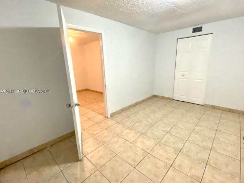 A room with light-colored tile flooring, white walls, and a white closet door — 4307 SW 9th ST # 4307, Miami FL 33134, MIAMI, FL