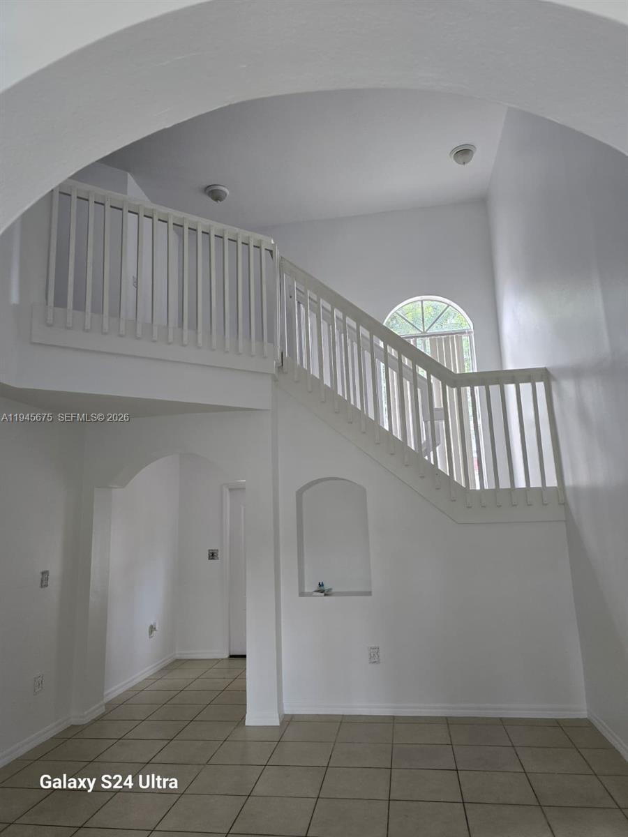 A white interior features a staircase with a wooden railing and a tiled floor — 13658 SW 142nd Ter, Miami FL 33186, MIAMI, FL