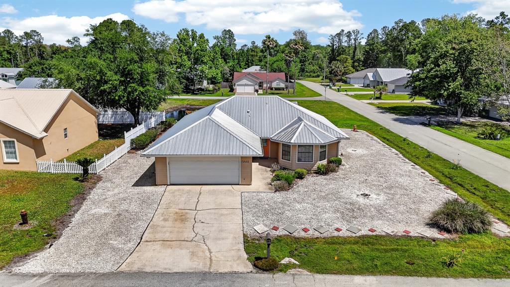 A single-story house with a metal roof, a two-car garage, and a gravel front yard — 7200 ANDREW JACKSON STREET, PALATKA, FL