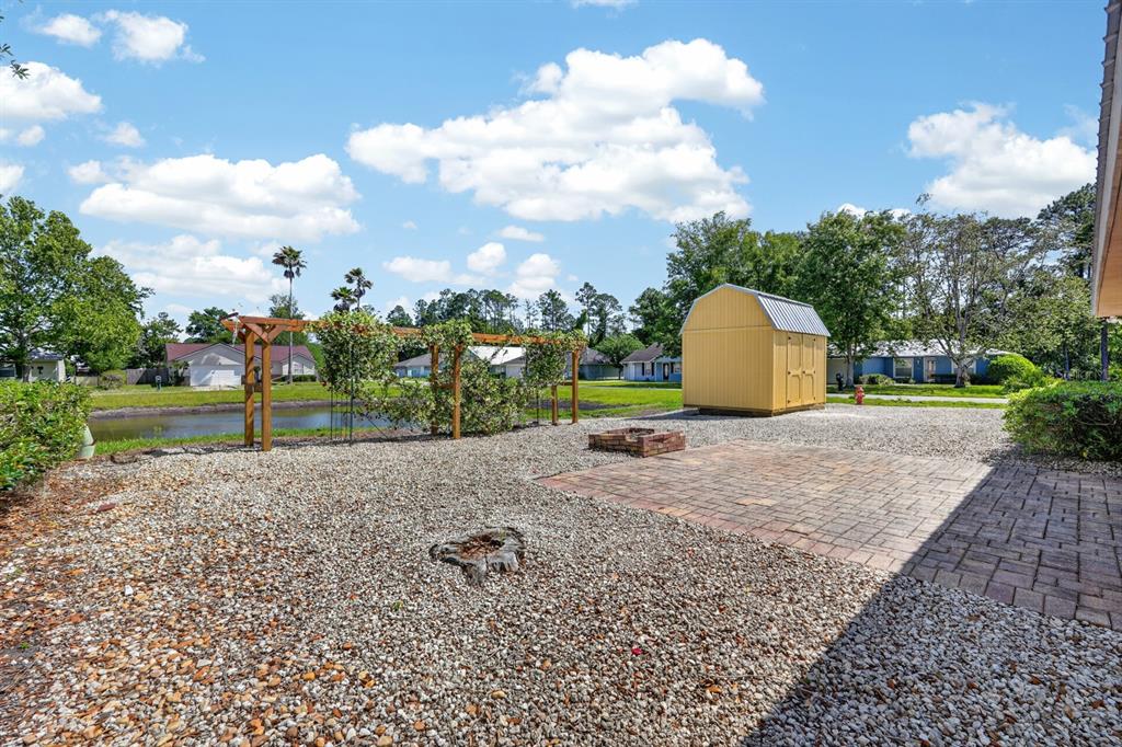 A backyard features a gravel area, a brick patio, a wooden pergola, and a storage shed — 7200 ANDREW JACKSON STREET, PALATKA, FL