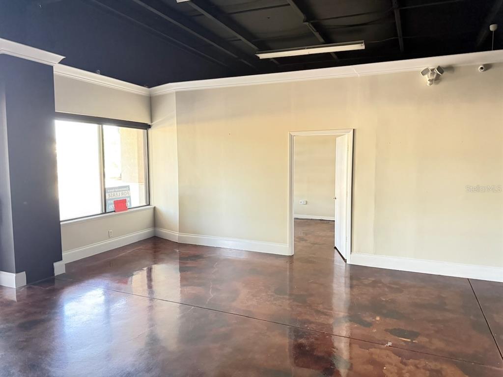 An empty commercial space features a dark ceiling, light walls, and a polished concrete floor — 2709 SW 27TH AVENUE UNIT 103, OCALA, FL