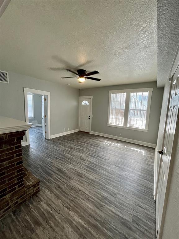 A living room features gray wood-look flooring, a brick fireplace, and a ceiling fan — 644 4TH AVENUE S, ST PETERSBURG, FL