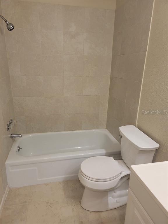 A bathroom features a white bathtub with a showerhead and a white toilet — 474 HINTON STREET, PORT CHARLOTTE, FL