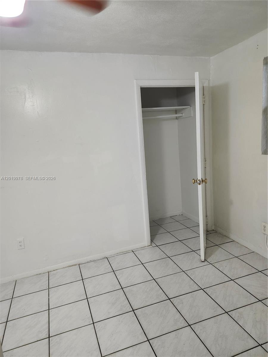 A room with white walls, white tile flooring, and an open closet with a shelf — 551 NE 139th St # 551, North Miami FL 33161, NORTH MIAMI, FL