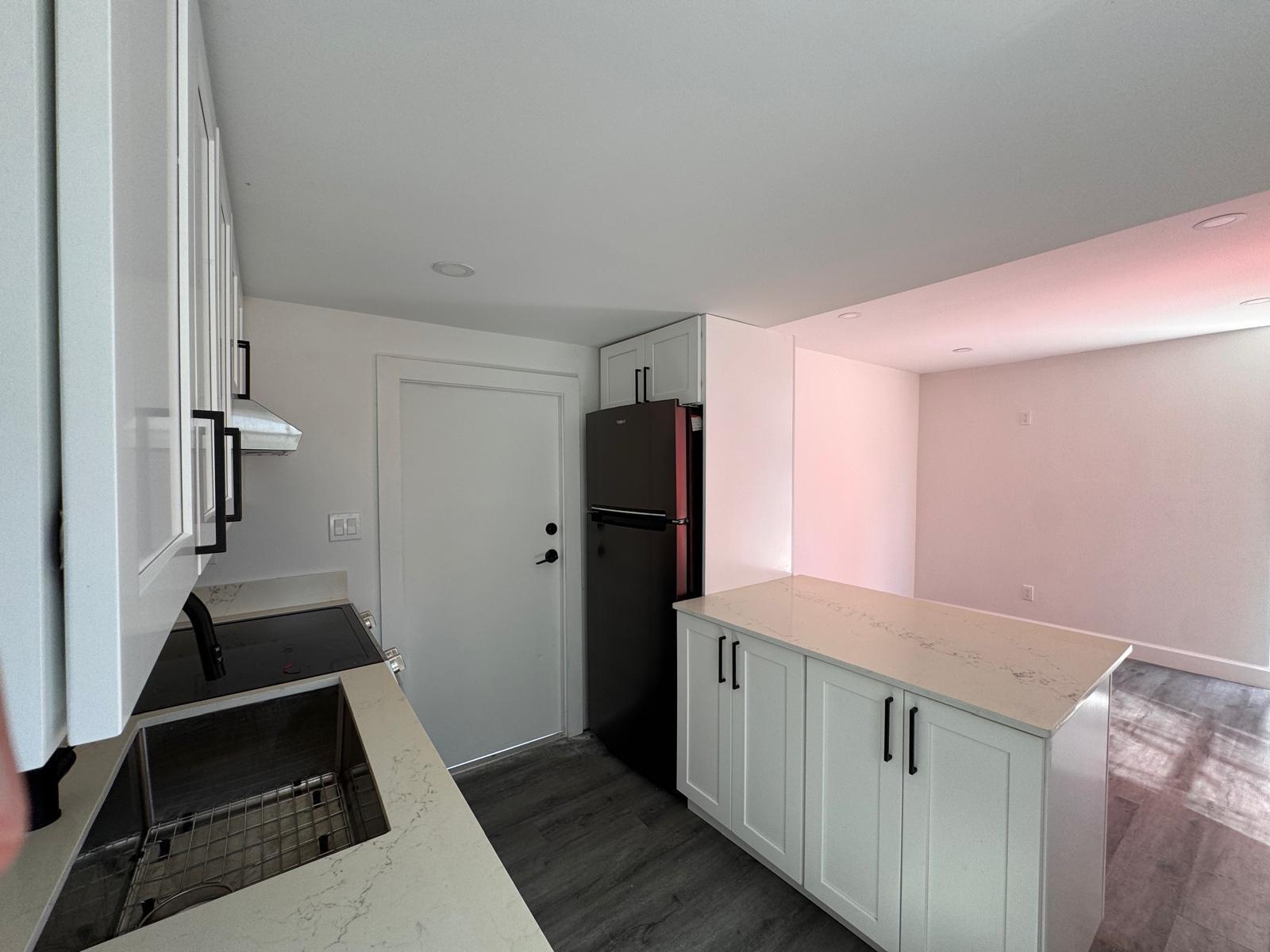 A kitchen features white cabinets, quartz countertops, a black refrigerator, and a stainless steel sink — 357 Hunting Club Avenue, Clewiston FL 33440, CLEWISTON, FL