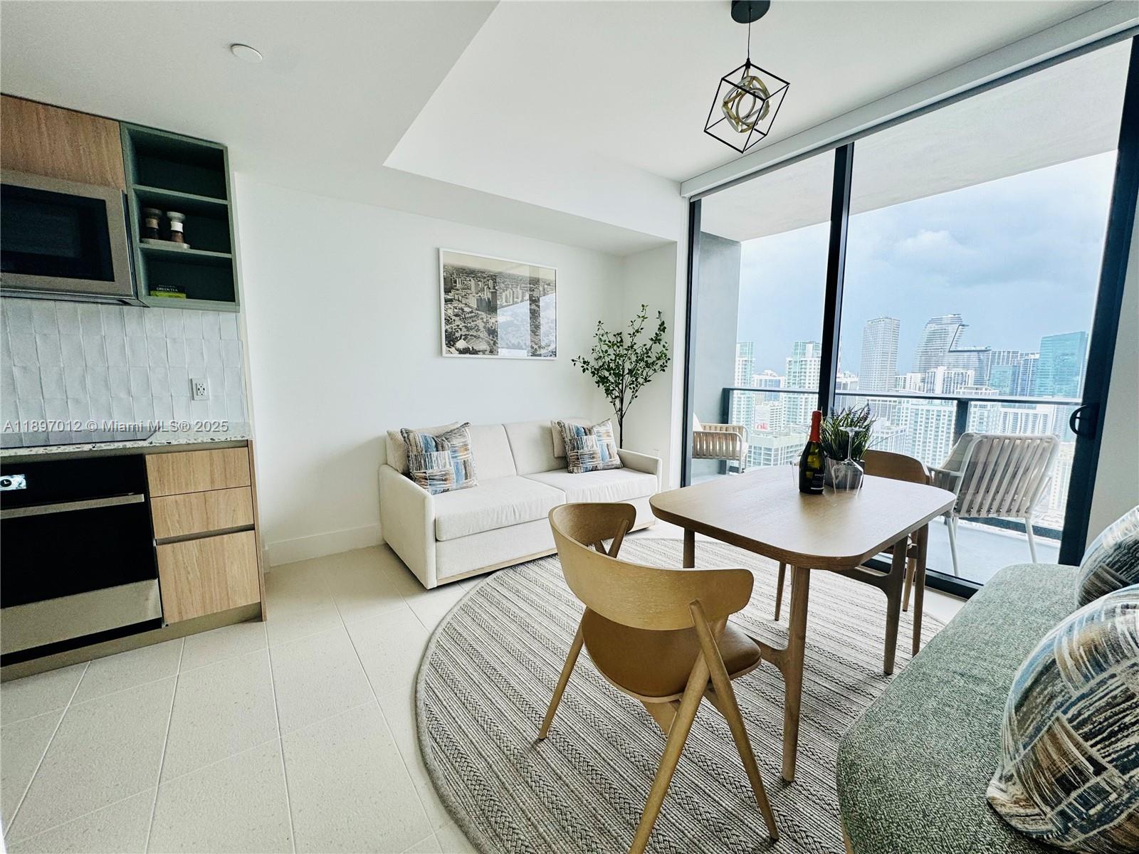 A modern apartment living area features a kitchen, dining set, sofa, and balcony view — 159 NE 6th St # 4314, Miami FL 33132, MIAMI, FL