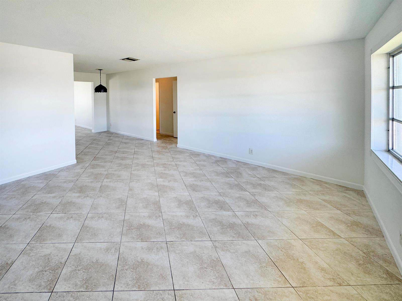 An empty room with white walls, beige tile flooring, and a window on the right — 514 SW 20th Street, Boynton Beach FL 33426, BOYNTON BEACH, FL