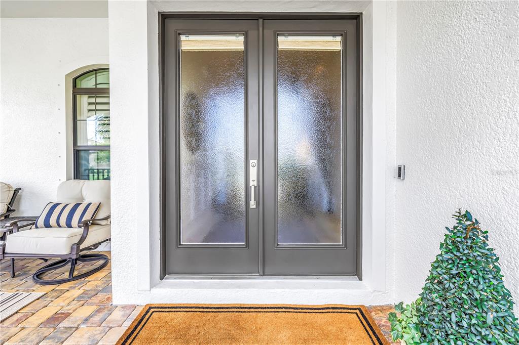 A double front door with textured glass panels sits at the entrance of a home — 6237 SIGNATURE POINTE LANE, BRADENTON, FL