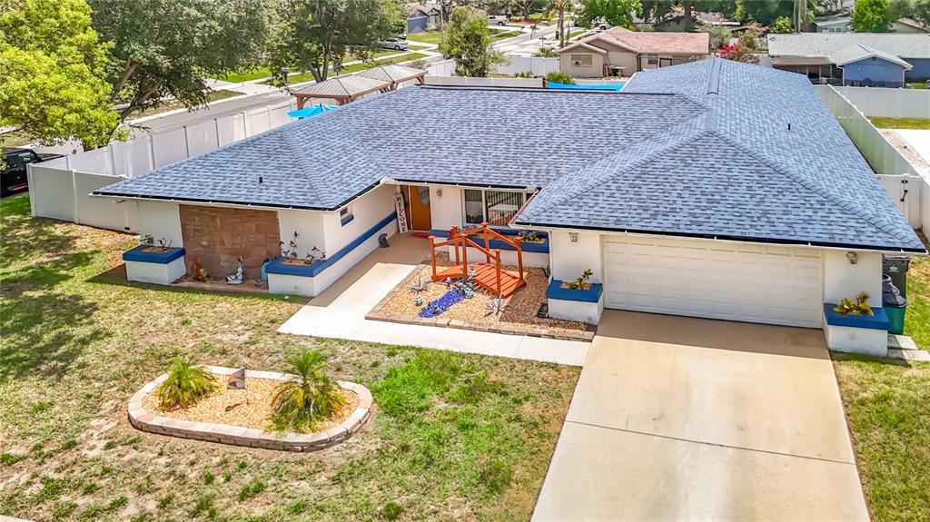 An aerial view of a single-story house with a blue roof, white walls, and a driveway — 3008 RIPPLEWOOD DRIVE, SEFFNER, FL
