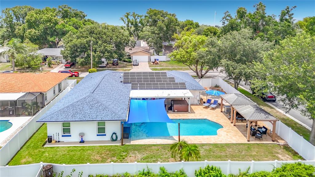 An aerial view of a house with a swimming pool, solar panels, and a patio — 3008 RIPPLEWOOD DRIVE, SEFFNER, FL