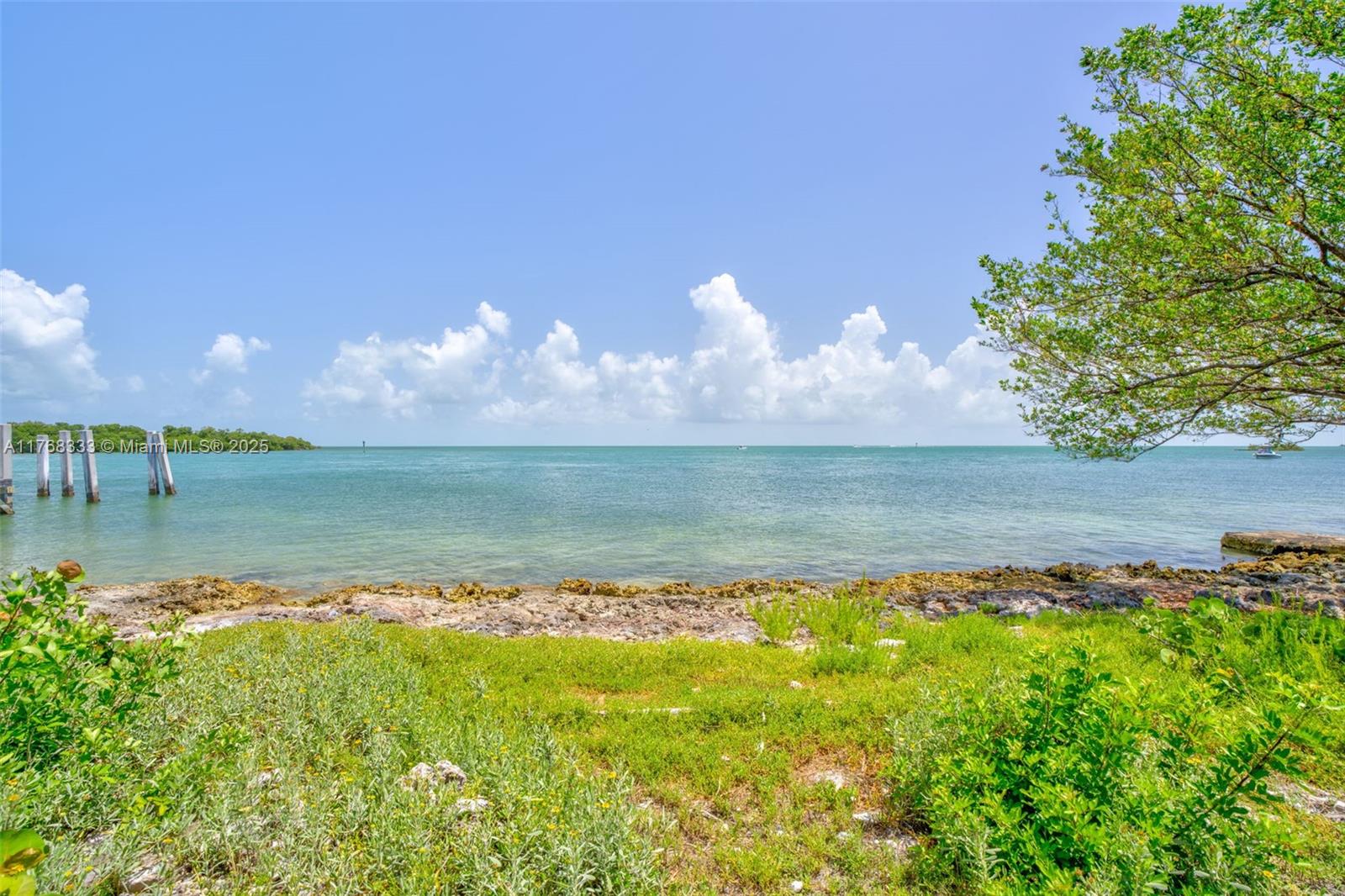 A view of a rocky shoreline and grassy area overlooking a calm, blue ocean — 14 125th Street Gulf, Marathon FL 33050, MARATHON, FL