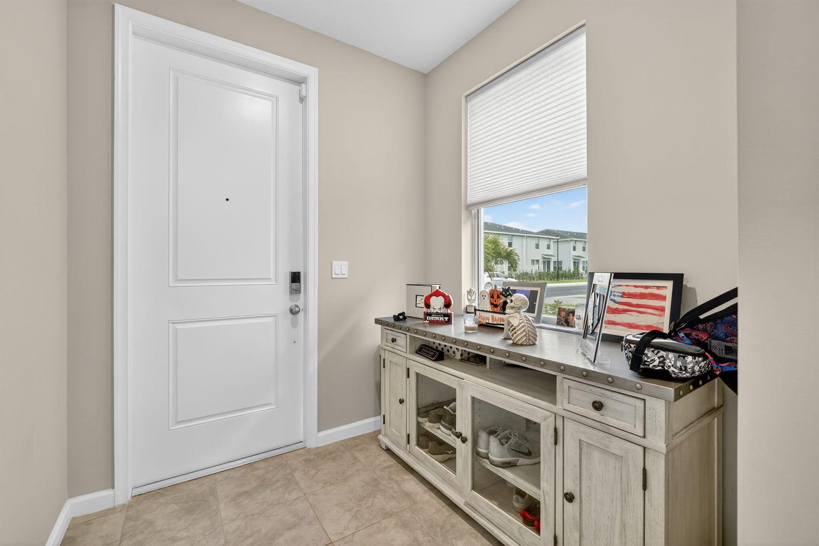 An entryway features a white front door, tile flooring, and a console table with decor — 5672 SE Edgewater Circle, Stuart FL 34997, STUART, FL