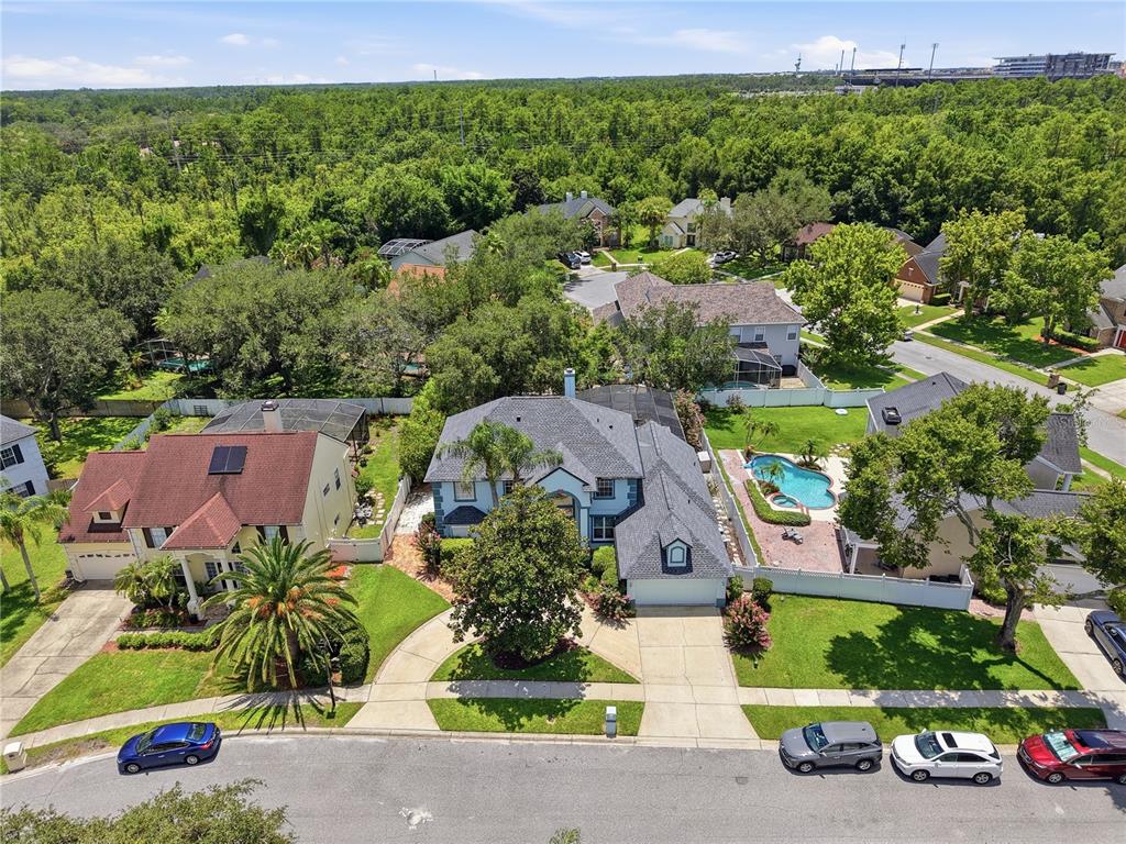 An aerial view shows two suburban houses with pools, driveways, and surrounding trees — 1307 HAMPSTEAD TERRACE, OVIEDO, FL
