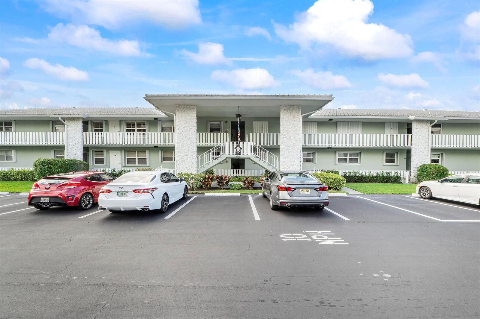 A two-story apartment building exterior with a central staircase and a parking lot in front — 5540 N Ocean Boulevard # 110, Ocean Ridge FL 33435, OCEAN RIDGE, FL