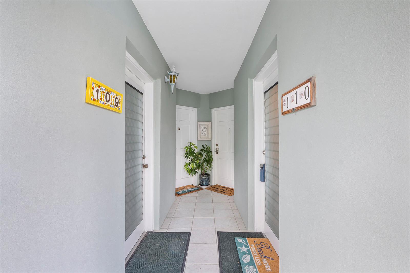 A hallway with light gray walls features two entrance doors with unit numbers 109 and 110 — 5540 N Ocean Boulevard # 110, Ocean Ridge FL 33435, OCEAN RIDGE, FL