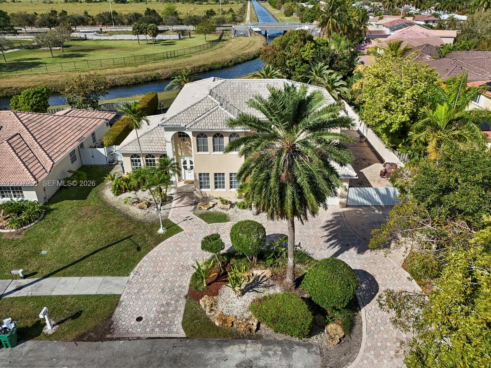 An aerial view shows a two-story house with a paved driveway and palm trees — 11230 SW 156th Ave, Miami FL 33196, MIAMI, FL