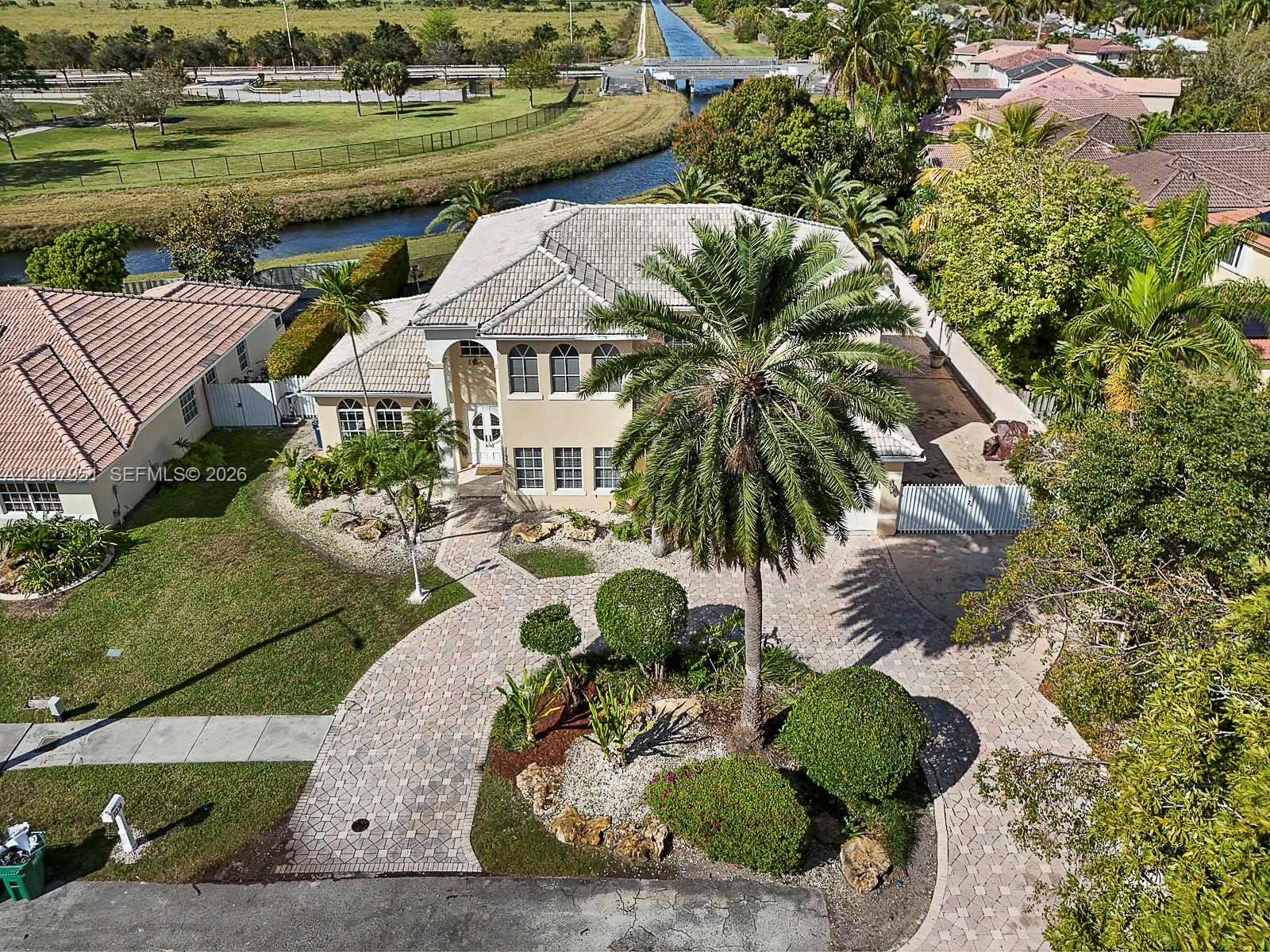 An aerial view shows a two-story house with a paved driveway and a large palm tree — 11230 SW 156th Ave, Miami FL 33196, MIAMI, FL