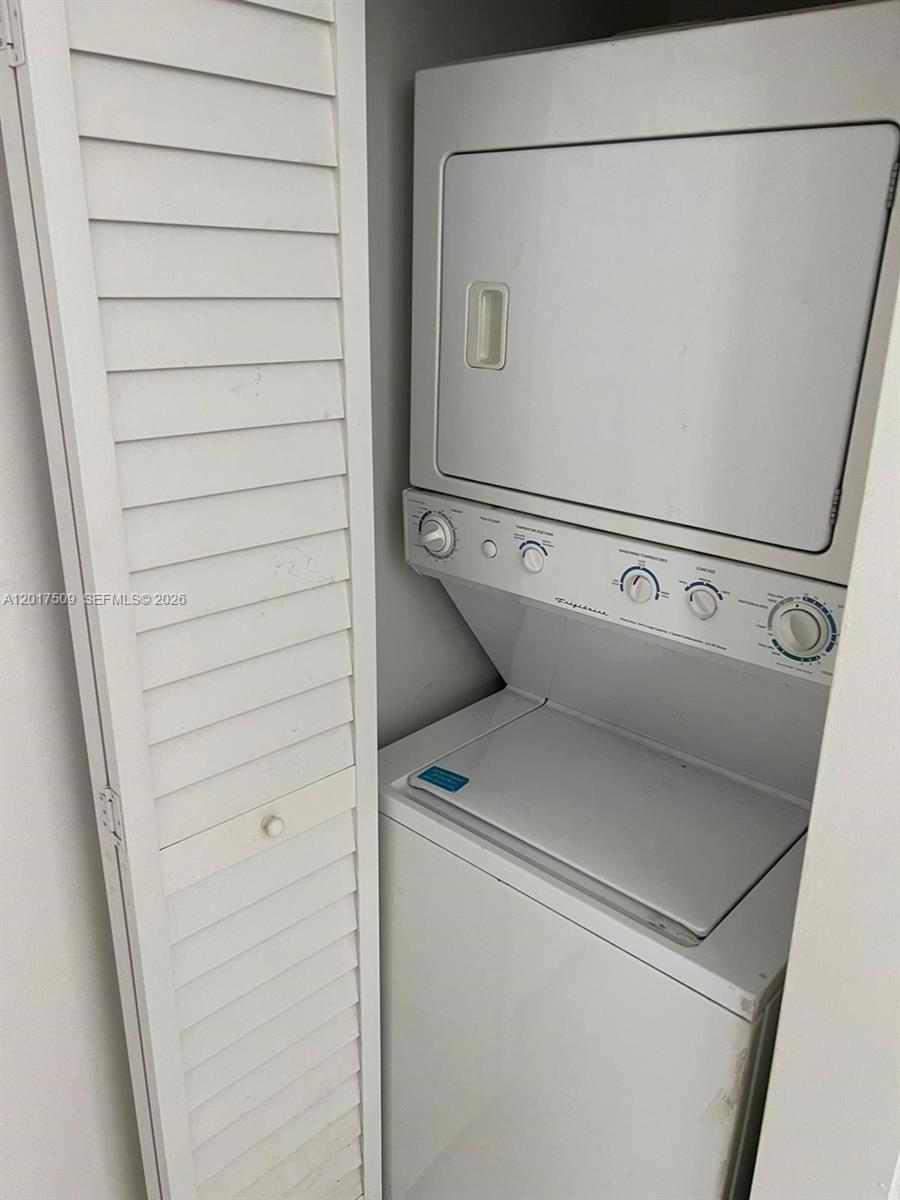 A white stacked Frigidaire washer and dryer unit sits in a small closet — MIAMI BEACH, FL