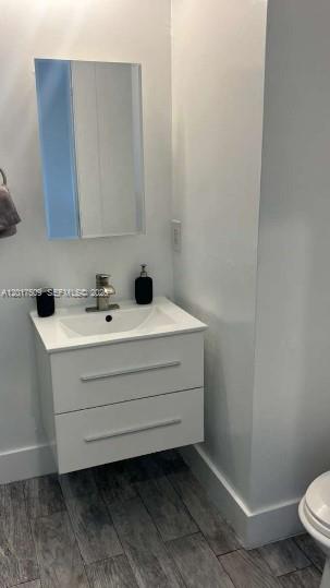 A modern bathroom features a white floating vanity with two drawers and a wall mirror — MIAMI BEACH, FL