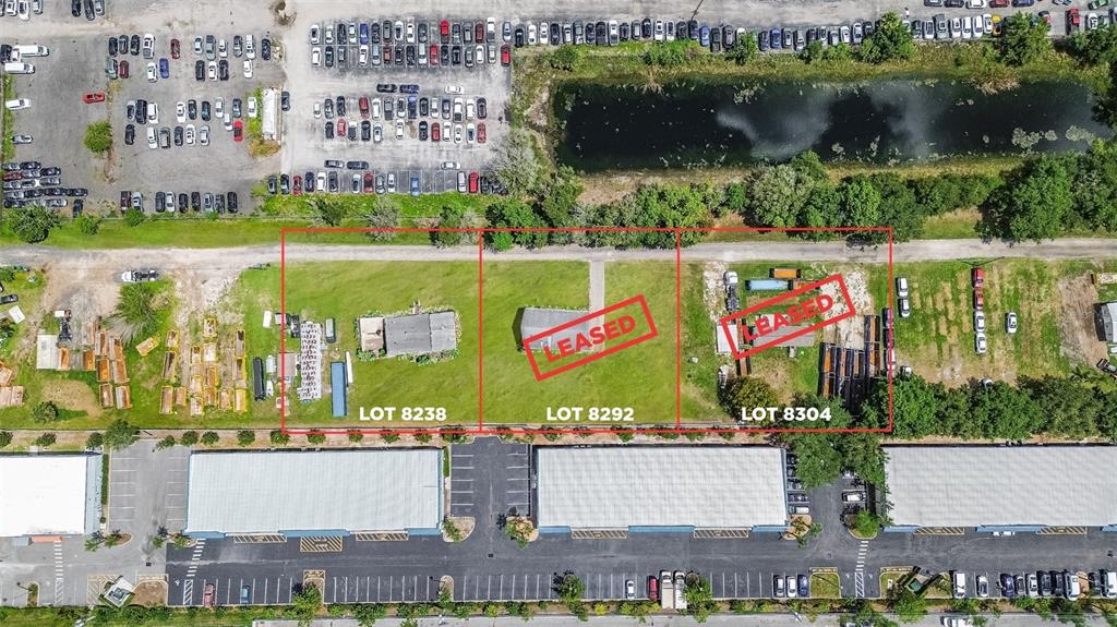 An aerial view shows three adjacent rectangular land lots with some structures and equipment — 8292 DAKOTA DRIVE, ORLANDO, FL