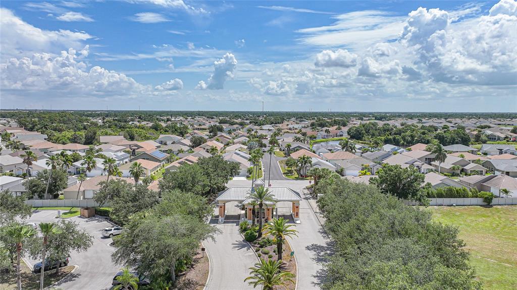 An aerial view of a gated community entrance with a guardhouse, palm trees, and houses — 24191 BUCKINGHAM WAY, PUNTA GORDA, FL