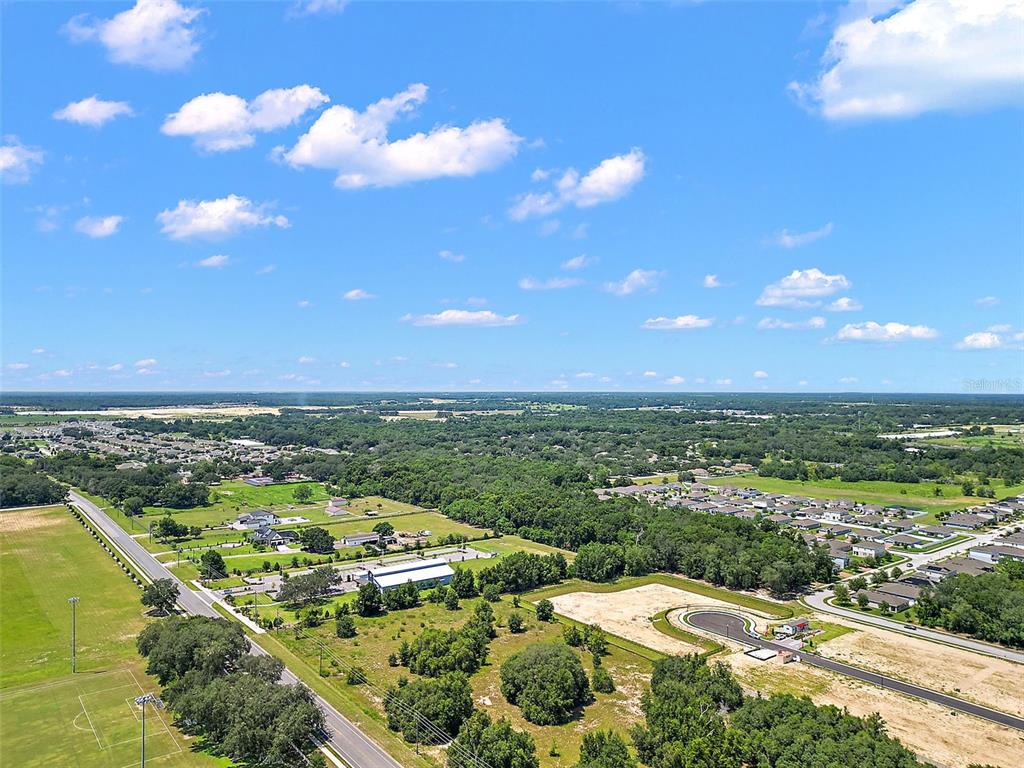 An aerial view shows a suburban landscape with residential developments, green spaces, and a road — 2295 APPY LANE, APOPKA, FL