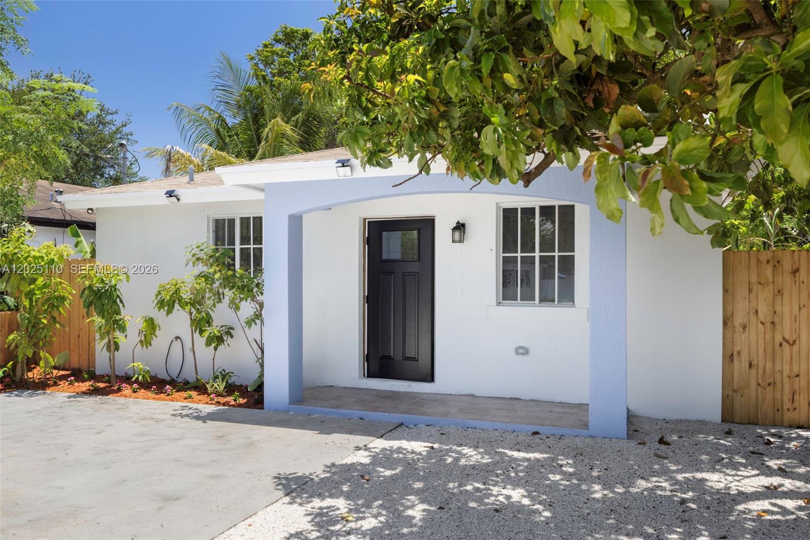 A white house with a black front door and a light blue arched entryway — 10204 SW 173rd St, Miami FL 33157, MIAMI, FL
