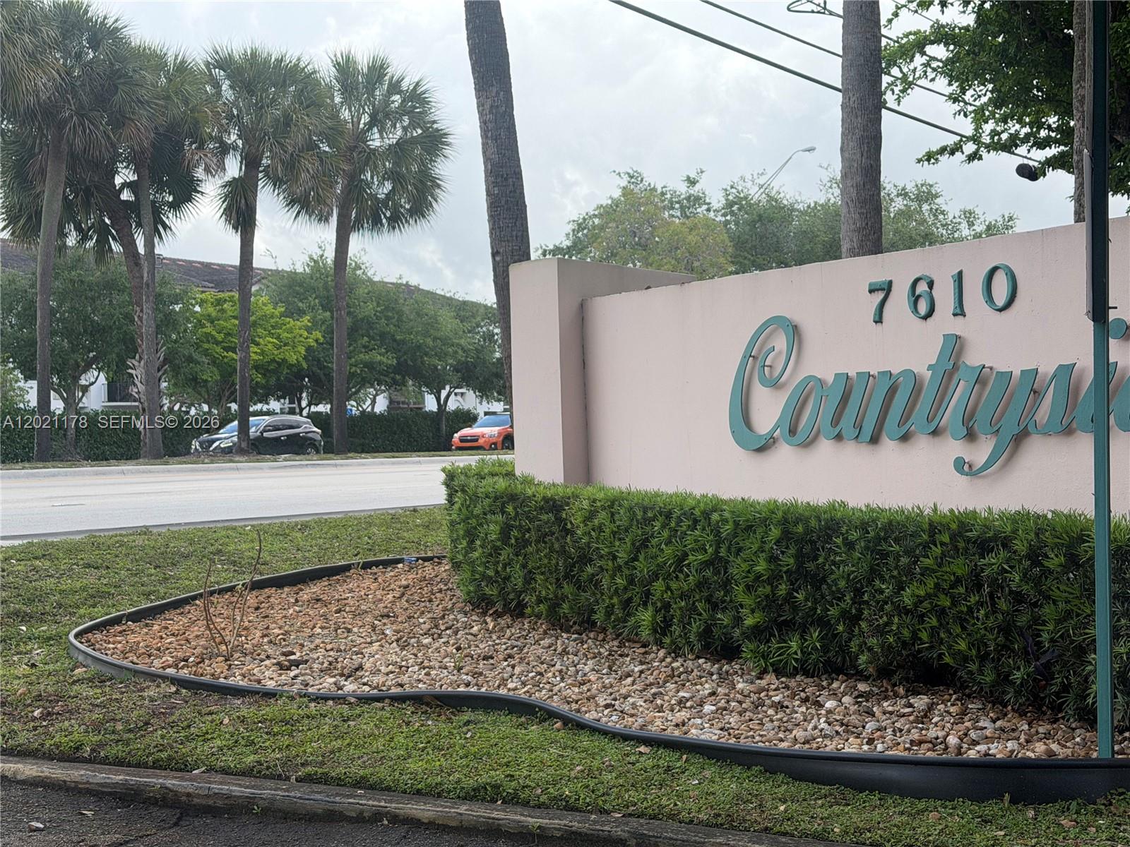 A beige monument sign with the number 7610 stands in front of a landscaped garden — 7610 Stirling Rd # 205G, Davie FL 33024, DAVIE, FL