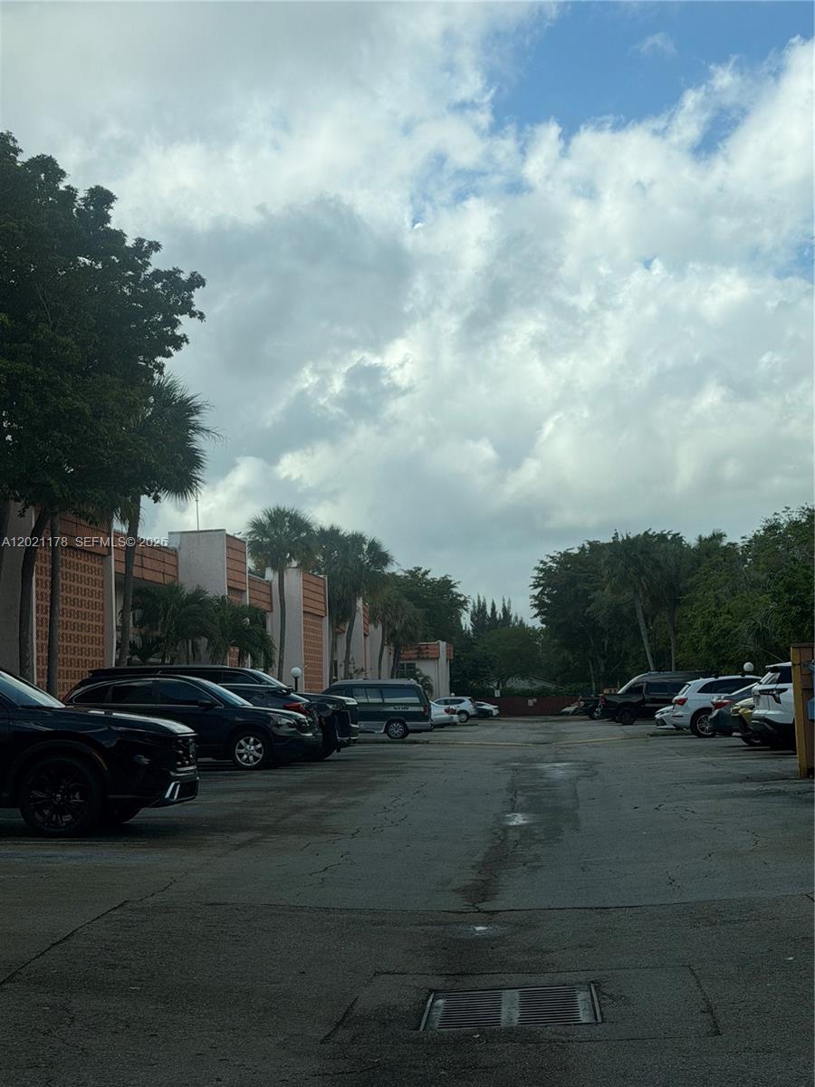 A parking lot sits in front of a multi-story building with palm trees — 7610 Stirling Rd # 205G, Davie FL 33024, DAVIE, FL