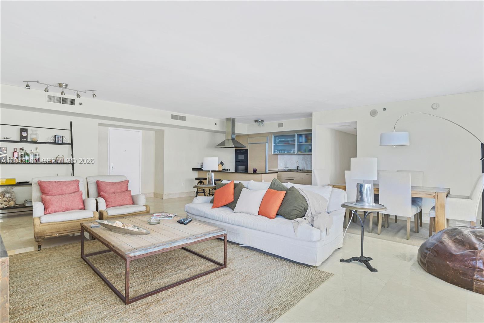 An open-concept living and dining area features a kitchen, neutral furniture, and light tile flooring — 1850 S Ocean Dr # 1410, Hallandale Beach FL 33009, HALLANDALE BEACH, FL