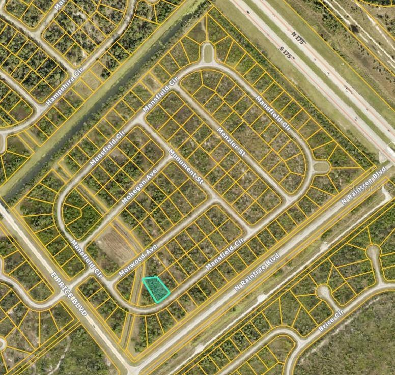 An aerial view shows a dense, wooded area adjacent to a paved road — 08 MANSFIELD CIRCLE, NORTH PORT, FL