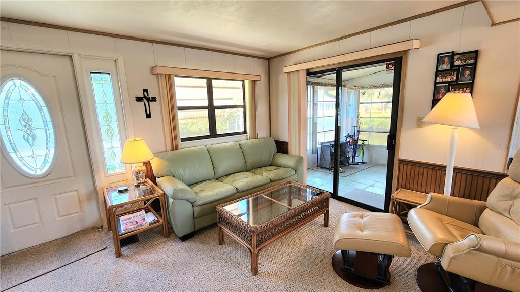 A living room features a light green sofa, a wicker coffee table, and a recliner — 3333 26TH AVENUE E UNIT 1292, BRADENTON, FL