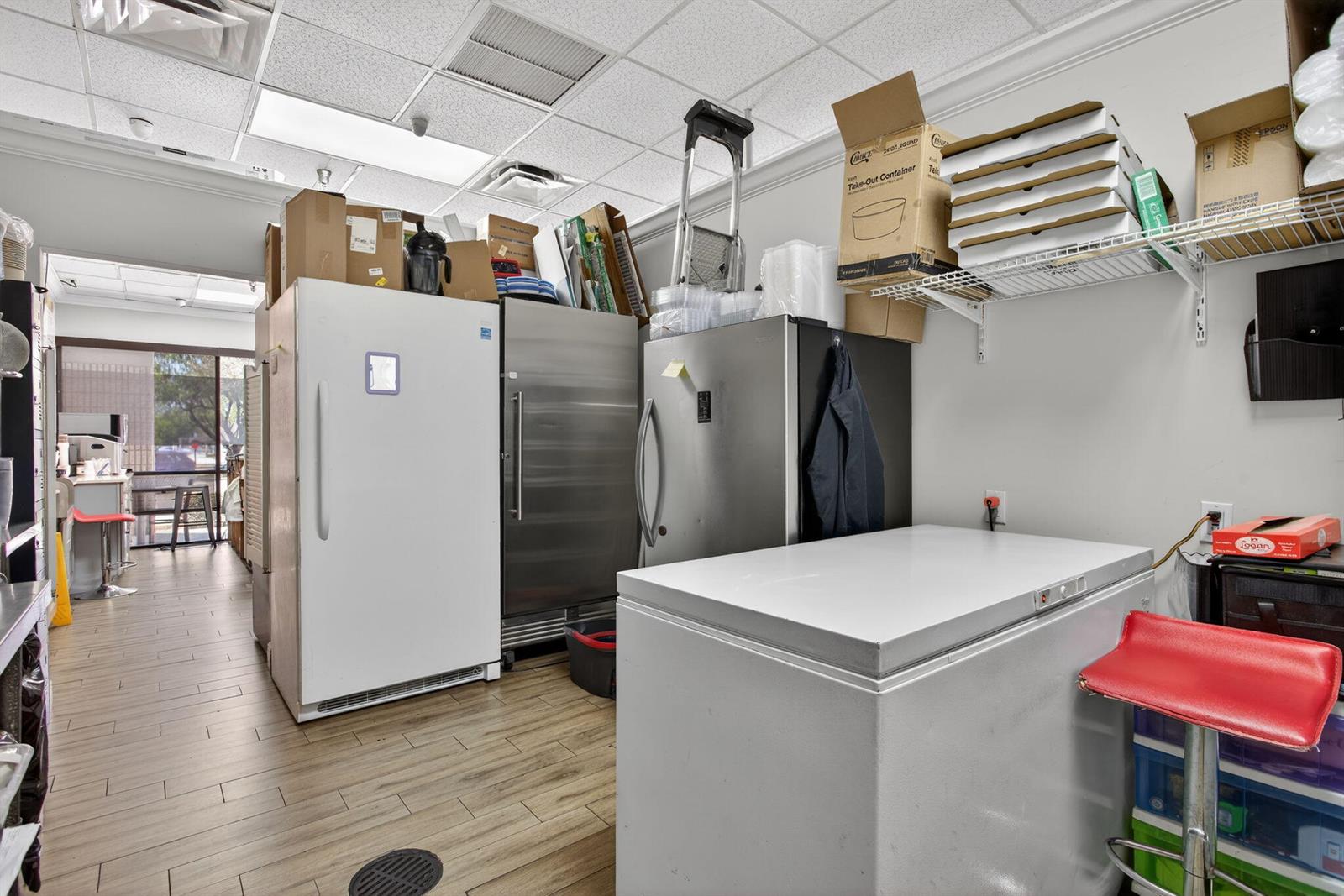 A commercial kitchen storage area features stainless steel refrigerators, a chest freezer, and wire shelving — Null W Null, Coconut Creek FL 33073, COCONUT CREEK, FL