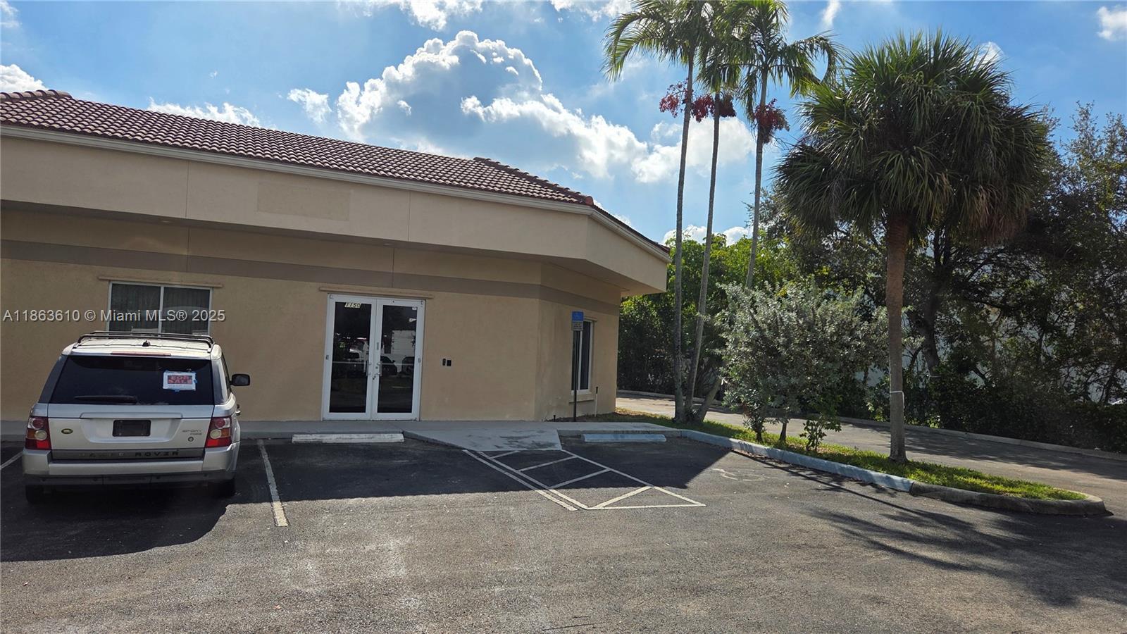 A silver SUV is parked in front of a tan commercial building with a tiled roof — 1150 SW 30th Ave, Pompano Beach FL 33069, POMPANO BEACH, FL